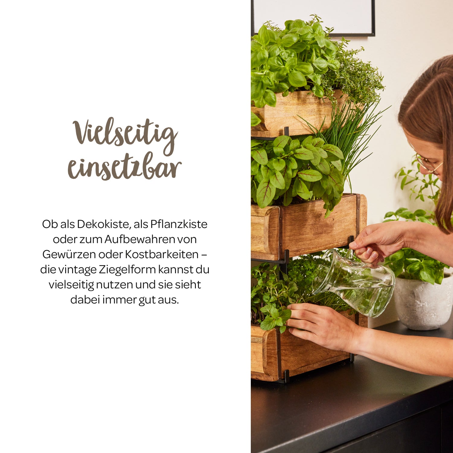 Une femme arrose des herbes dans des boîtes en bois empilées sur un comptoir de cuisine.