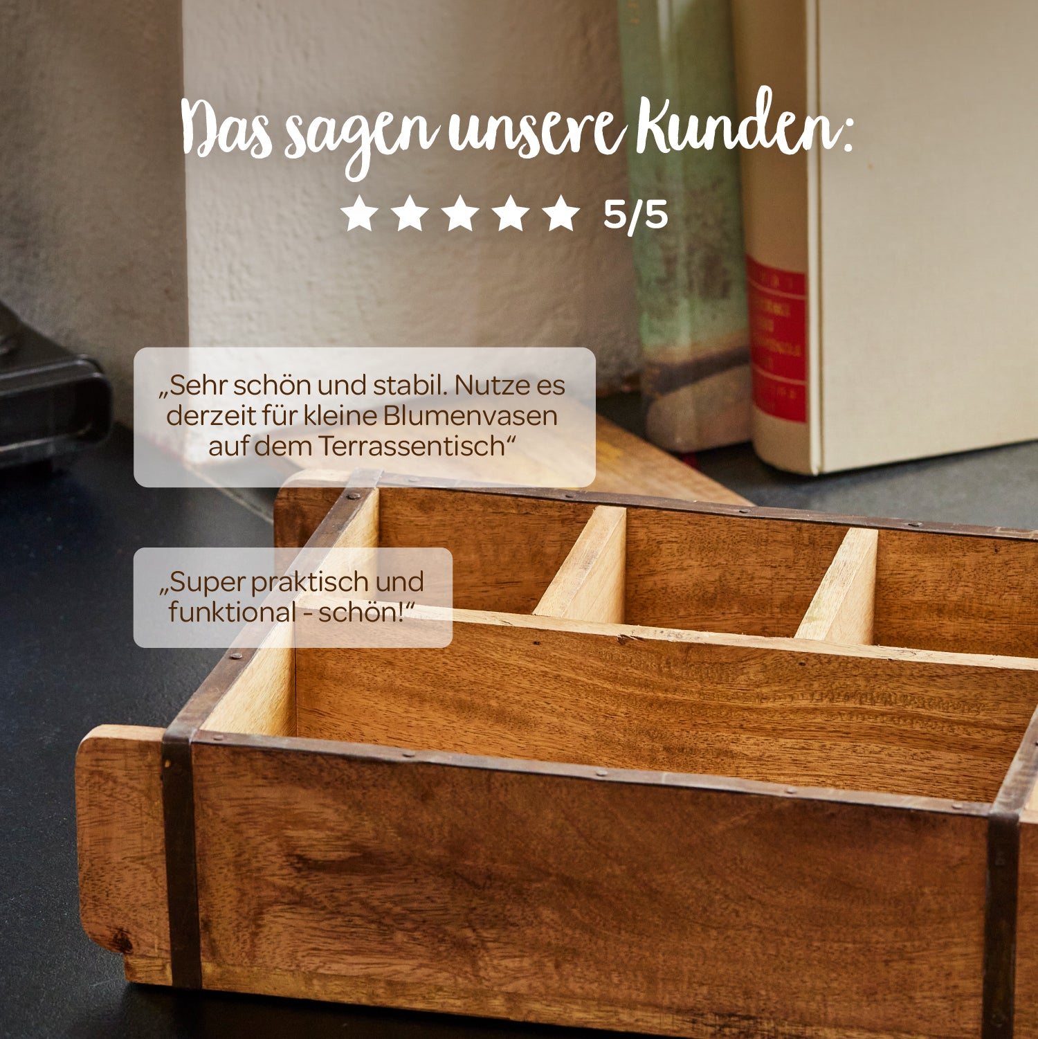 Une boîte en bois avec des compartiments se trouve sur une table, avec des livres en arrière-plan ; au-dessus se trouvent des avis clients en allemand et cinq étoiles avec une note de 5/5.