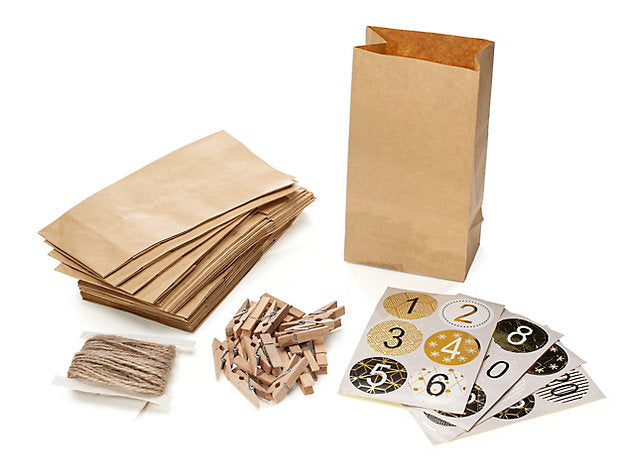 Kit de bricolage pour un calendrier de l'Avent avec des sacs en papier brun, des pinces en bois, de la ficelle et des autocollants numérotés.