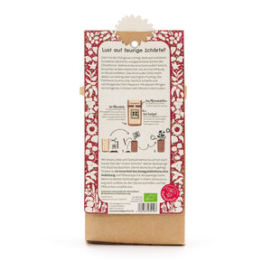 Dos d'un emballage contenant des instructions pour planter du piment, entouré d'un motif floral rouge, avec texte et illustrations en allemand.
