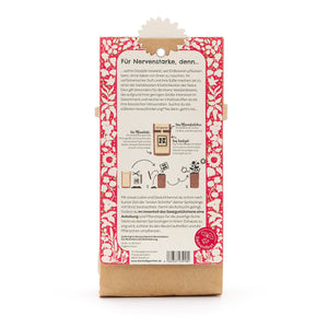 Dos d'un emballage avec un motif floral rouge, une description en texte allemand et des instructions pour planter des fraises.
