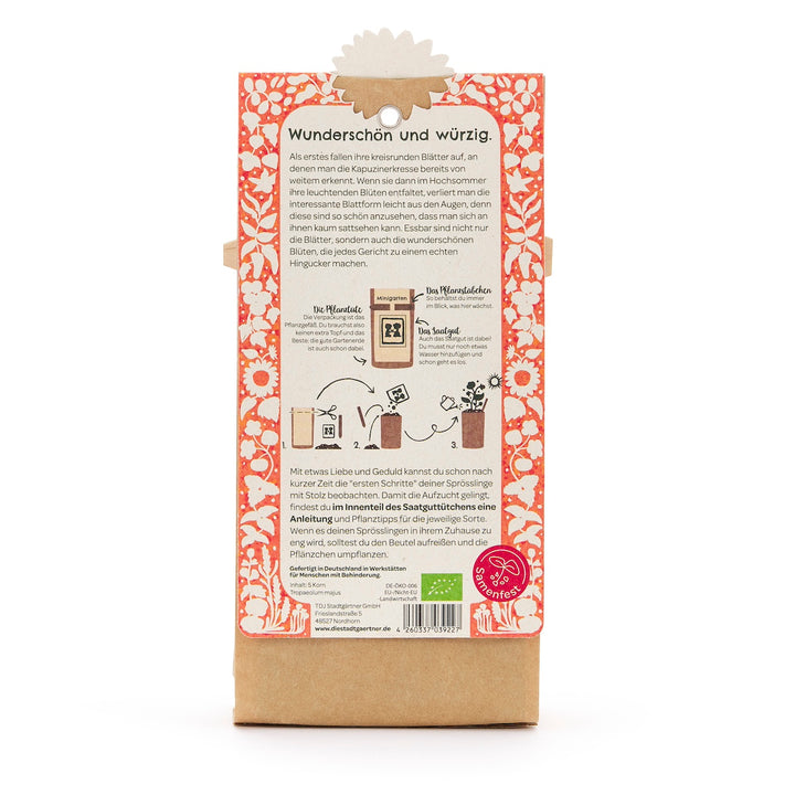 Dos d'un sachet de graines avec description en allemand, illustrations de semis et un motif floral orange et blanc.
