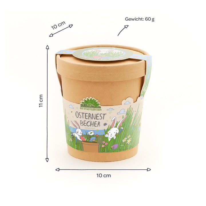 Gobelet en papier avec motif de Pâques, inscription "Easter Nest Cup", dimensions 10 x 11 cm, poids 60 g, décoré de lapins et d'une prairie printanière.