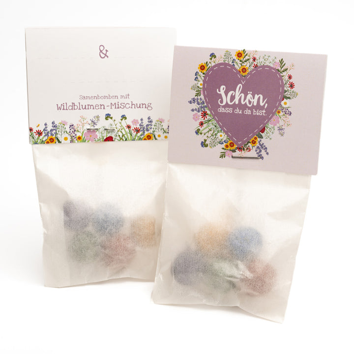 Deux sachets de bombes de graines de fleurs sauvages, décorés de motifs floraux et d'un cœur avec l'inscription « C'est super que tu sois là ».