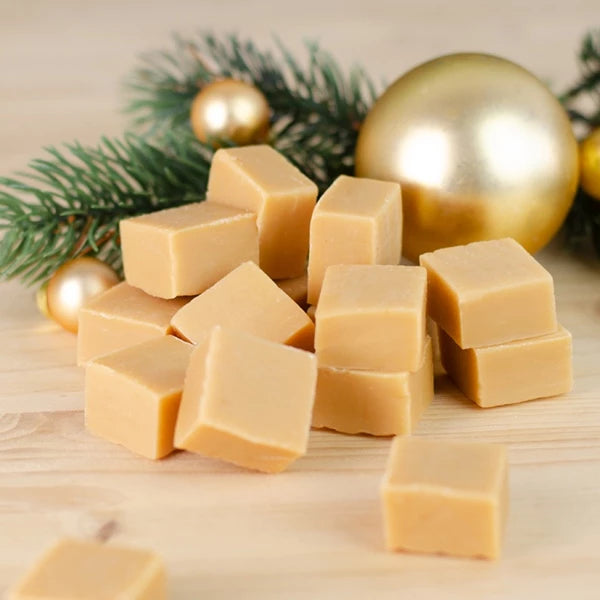 Pile de cubes de caramel avec des branches de sapin et des boules de Noël en arrière-plan