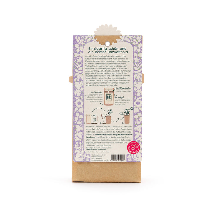 Dos d'un emballage avec un motif floral violet, un texte sur le caractère écologique de l'arbre Kiri, des instructions de plantation et le logo du Seed Festival en bas à droite.