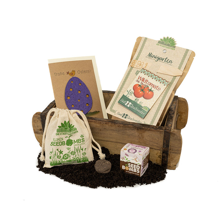 Kit horticole avec bombes à graines, kits de culture de plantes, carte de Pâques et terreau présenté dans une brouette en bois"