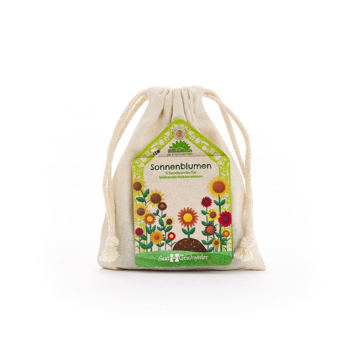 Sac en tissu avec étiquette "Sunflower Seed Bombs" et illustrations de fleurs colorées.