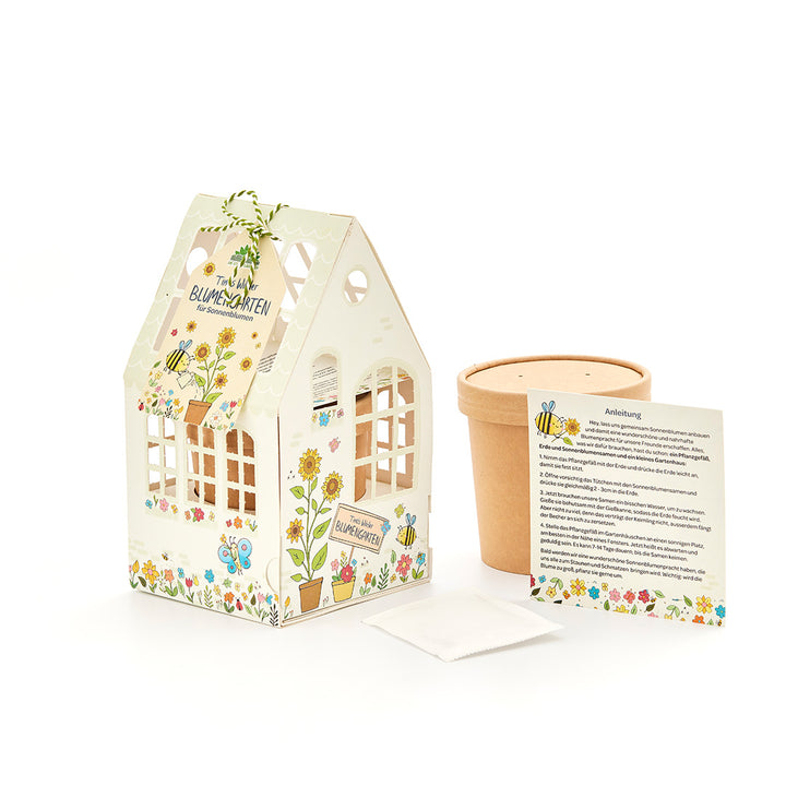 Kit de bricolage pour jardin fleuri avec maison décorative, pot de fleurs, sachet de graines et instructions en allemand.