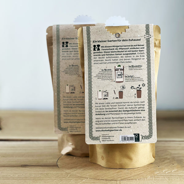 Deux sacs en papier brun avec des instructions pour un mini jardin au dos, posés sur une table en bois.