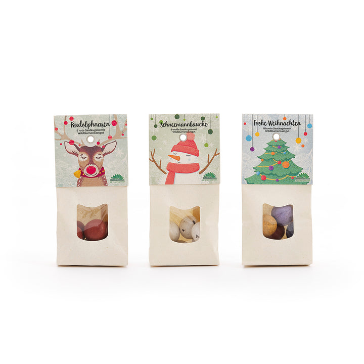 Trois sacs de bonbons de Noël décorés d'illustrations d'un renne, d'un bonhomme de neige et d'un sapin de Noël.