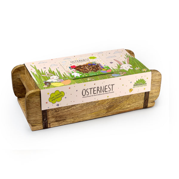 Bol en bois avec décoration et emballage de Pâques, étiqueté "Nid de Pâques" et motifs de lapin.
