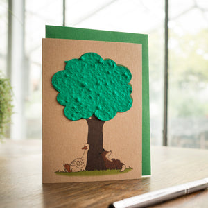 Carte de vœux faite à la main avec un arbre en papier vert, des poulets et un chien en dessous.