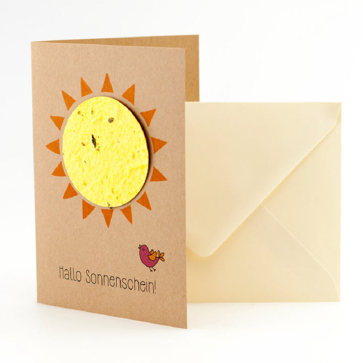 Carte de vœux avec un motif de soleil et l'inscription "Hello Sunshine!" à côté d'une enveloppe de couleur crème.