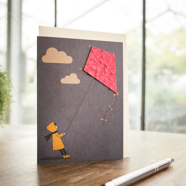 Carte de voeux avec illustration d'un enfant faisant voler un cerf-volant.
