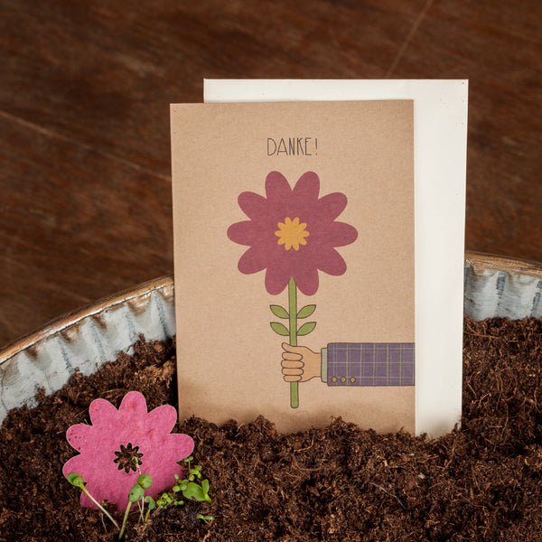 Carte de remerciement avec motif de fleurs sur terre.