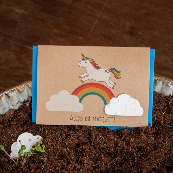 Carte de vœux avec une licorne et un arc-en-ciel au sol, texte "Tout est possible !"
