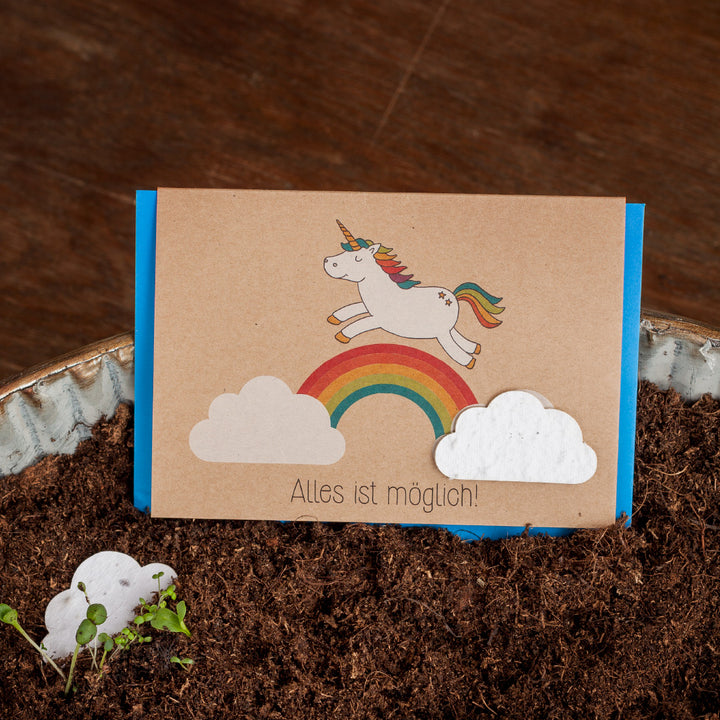 Carte de vœux avec une licorne et un arc-en-ciel au sol, texte "Tout est possible !"
