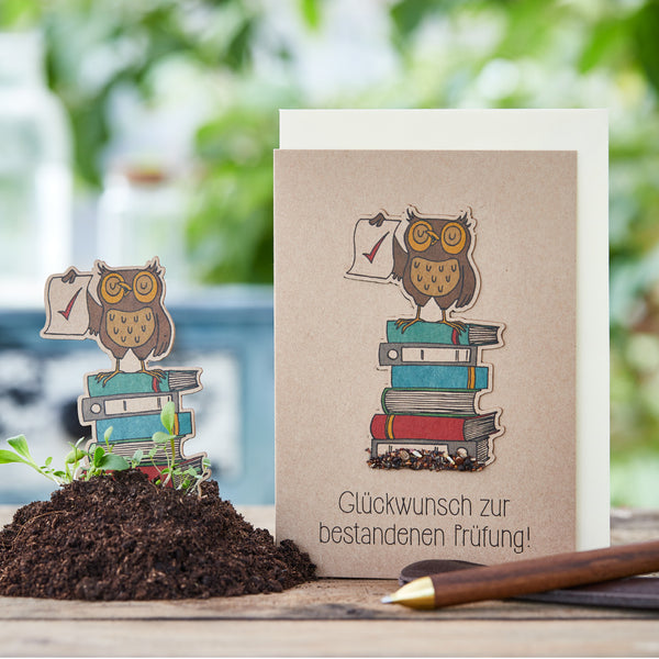 Carte de félicitations avec un hibou sur une pile de livres et le texte « Félicitations pour avoir réussi l'examen ».