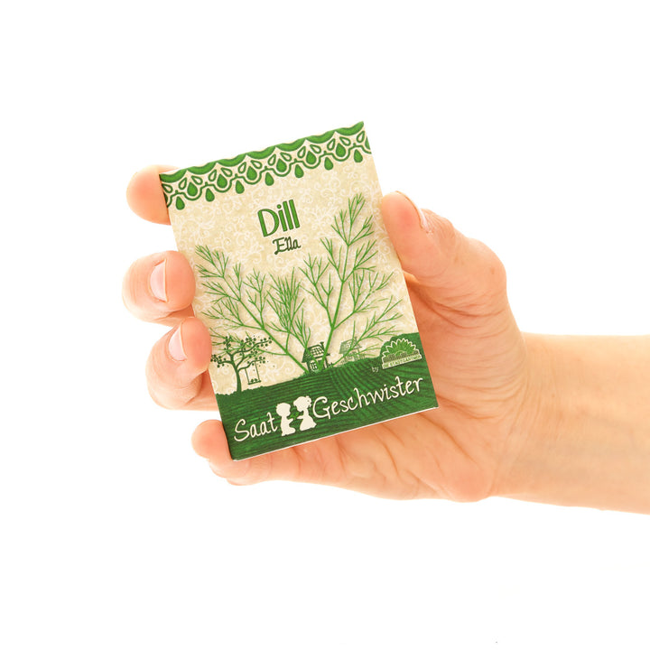 Main tenant un sachet de graines d'aneth étiqueté « Saati & Geschwister ».