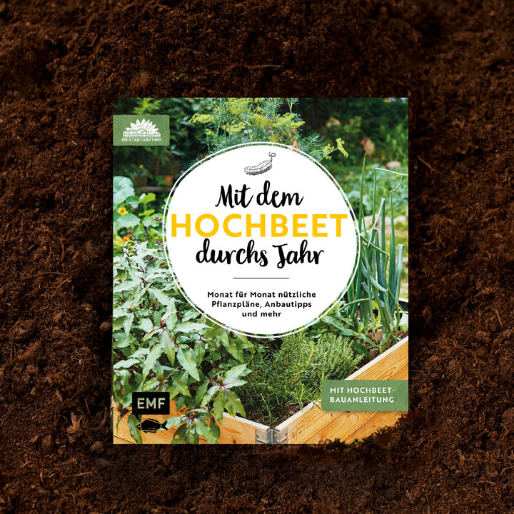 Livre de jardinage "Avec le lit surélevé tout au long de l'année" sur le sol.