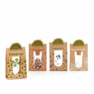 Quatre petits sacs cadeaux étiquetés « Porte-bonheur », « Personne préférée », « Couette » et « Exauceur de vœux », chacun avec des motifs végétaux différents.