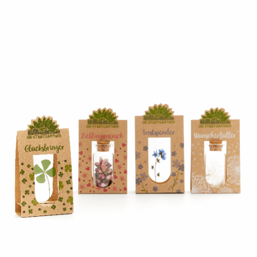 Quatre petits sacs cadeaux étiquetés « Porte-bonheur », « Personne préférée », « Couette » et « Exauceur de vœux », chacun avec des motifs végétaux différents.