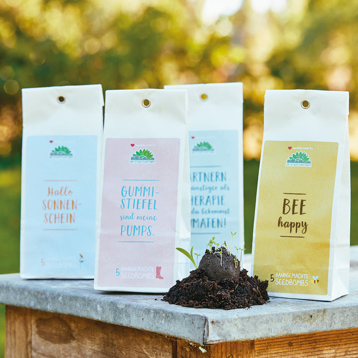 Bombes de graines emballées avec des dictons amusants sur une base en pierre dans le jardin.