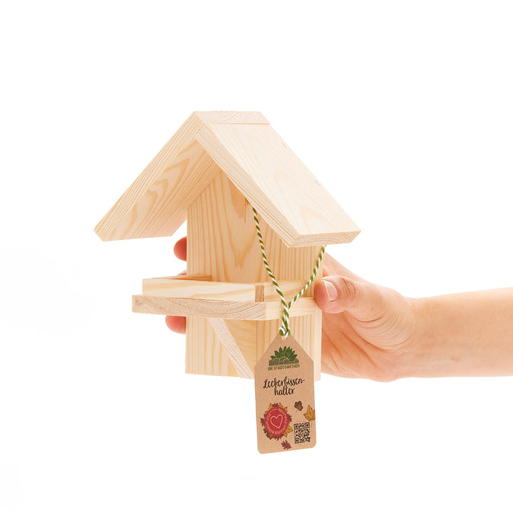 Nichoir en bois tenu par une main avec étiquette de prix.