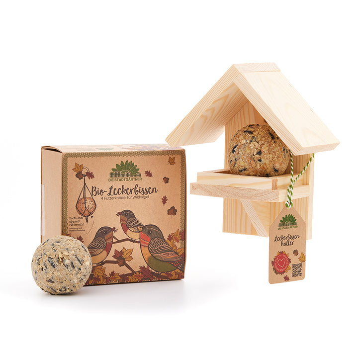 Friandises pour oiseaux biologiques avec mangeoire et emballage sur fond blanc.