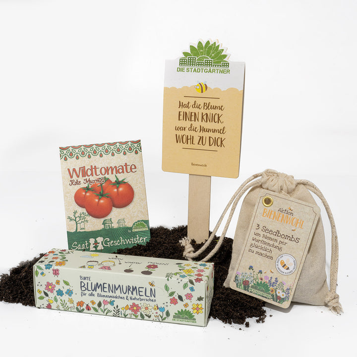 Produits de jardinage sur terre, dont un sac de graines de « tomates sauvages », des « billes de fleurs », des sachets pour le « bien-être des abeilles » et un panneau « Les jardiniers de la ville ».