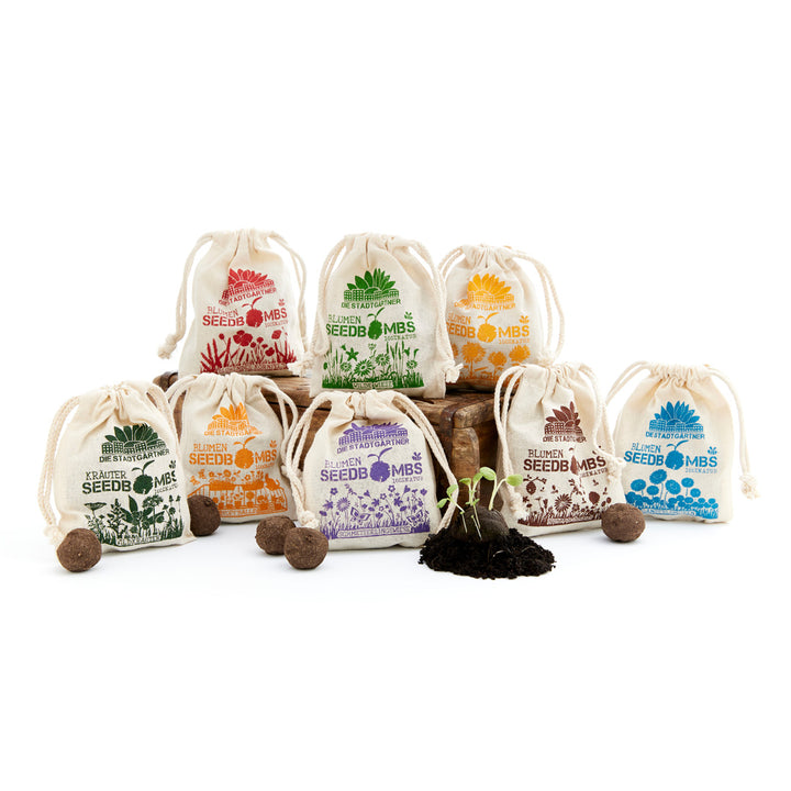 Sacs en tissu de différentes couleurs avec des graines sur fond blanc.
